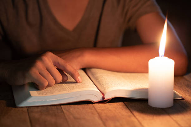 istock Poor children read books using candles for lighting., Disadvantaged Children doing homework, Education Concept. 1186518770