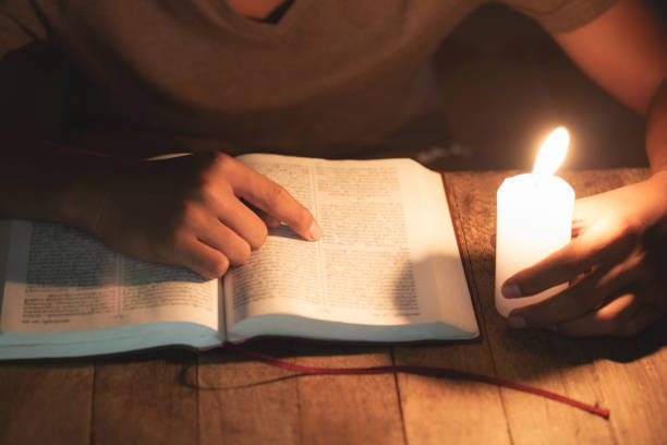 istock Poor children read books using candles for lighting., Disadvantaged Children doing homework, Education Concept. 1186518777