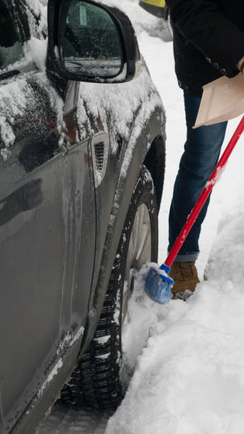 istock Scraping the snow of a car using the brush. 1186526385