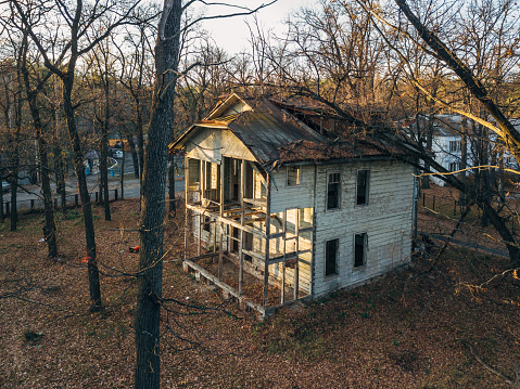 Old creepy wooden abandoned haunted mansion, aerial view.