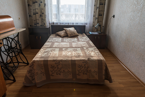 Interior of typical soviet style apartment. Old furniture and retro design in the bedroom