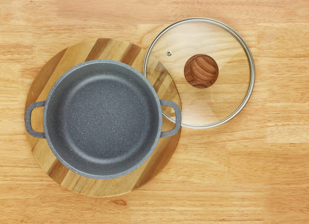 istock saucepan and round cutting board on the wooden table, top view 1186532255