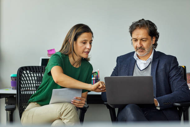 istock Businessman explaining colleague over laptop 1186532946