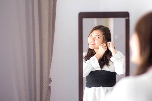 istock young woman put on ear ring before goes to work 1186533070