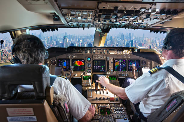 Cockpit of a modern passenger aircraft. Pilots at work. The cockpit of a modern passenger aircraft in flight. A view from the cockpit to the skyscrapers of the business center of a huge city. piloting photos stock pictures, royalty-free photos & images