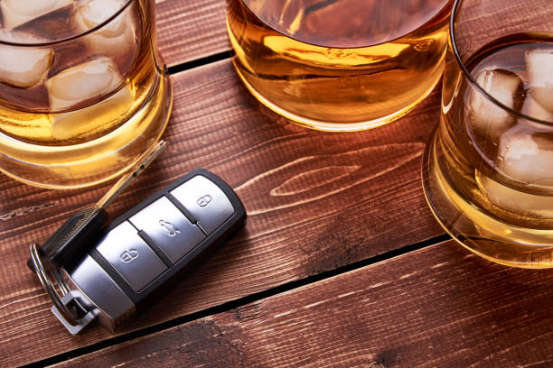 Still life on old wooden table top. Car keys, several glasses and a bottle of whiskey or alcohol. Suitable for drunk driving. Still life on old wooden table top. Car keys, several glasses and a bottle of whiskey or alcohol. Suitable for drunk driving. driving under the influence stock pictures, royalty-free photos & images