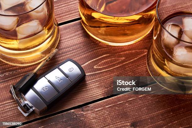 Still Life On Old Wooden Table Top Car Keys Several Glasses And A Bottle Of Whiskey Or Alcohol Suitable For Drunk Driving Stock Photo - Download Image Now