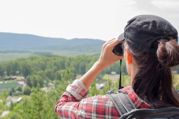 istock Hiker using binoculars and looking at nature, lake, mountain and trees in summer, close up 1186542045