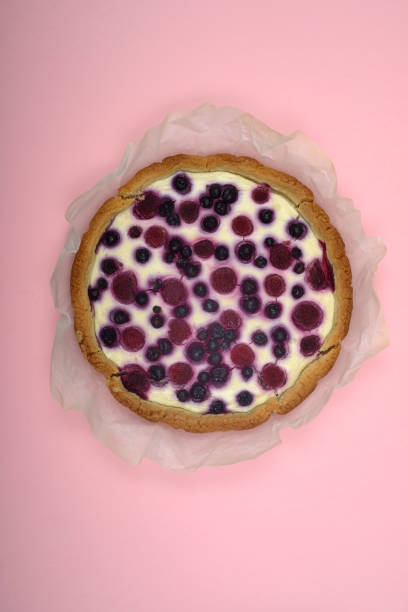 istock round berry pie on baking paper and on a pink background 1186544321