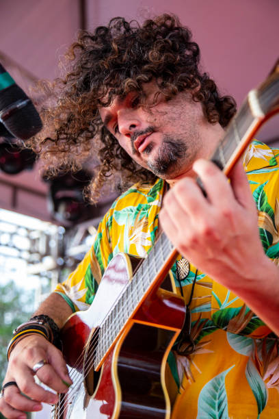 istock Man singing and playing acustic guitar at a concert 1186546808