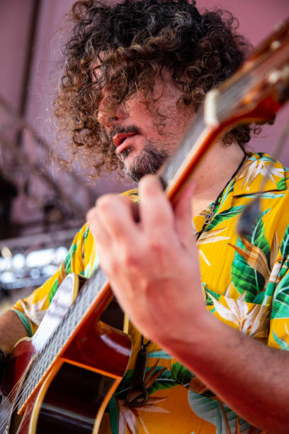 istock Man singing and playing acustic guitar at a concert 1186546839