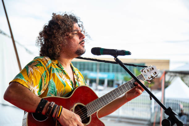 istock Man singing and playing acustic guitar at a concert 1186546960