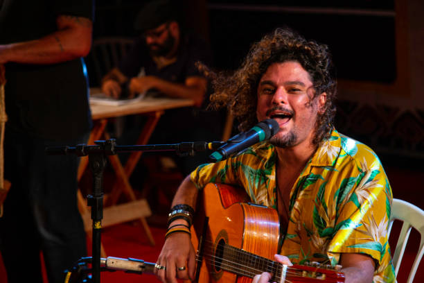 Man singing and playing acustic guitar at a concert