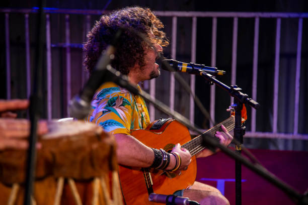 istock Man singing and playing acustic guitar at a concert 1186547051