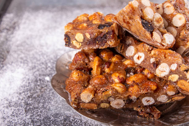 istock Italian sweet nuts, hazelnuts, almonds, figs, honey dessert over on red plate. 1186548342