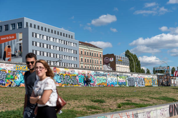 sección de la galería del lado este del muro de berlín - graffiti paintings men walking fotografías e imágenes de stock