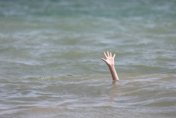 istock boy asking SOS on the sea 1186549513