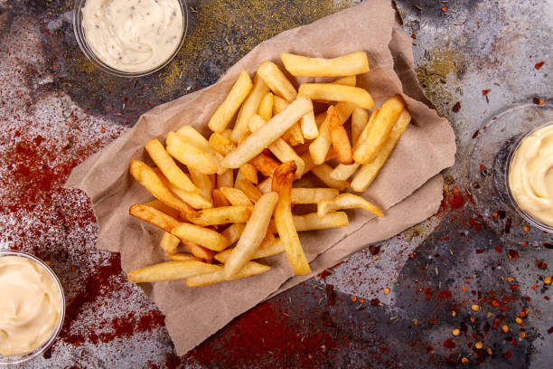istock French fries chips potato and sauces on black stone slate over rusty background. top view 1186553208