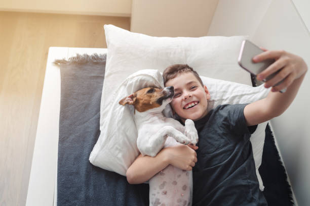 istock A young boy with a dog in a cozy interior. 1186556492