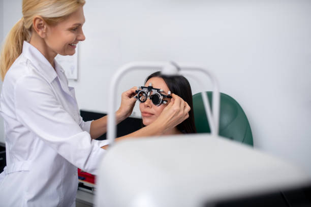 istock Blonde eye doctor smiling while examining pleasant patient 1186562815