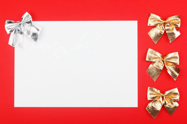 istock Blank white paper with gold and silver holidays bows on red background. 1186563913