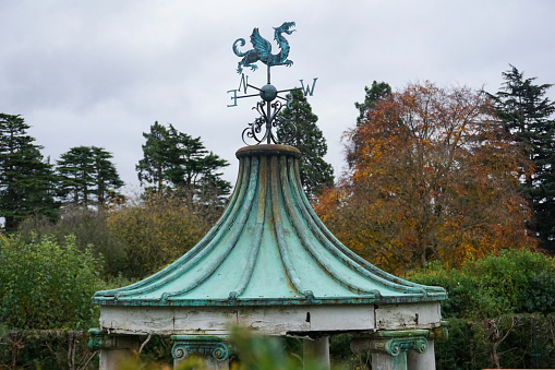 An old weathered weather vane atop a weathered gazebo.