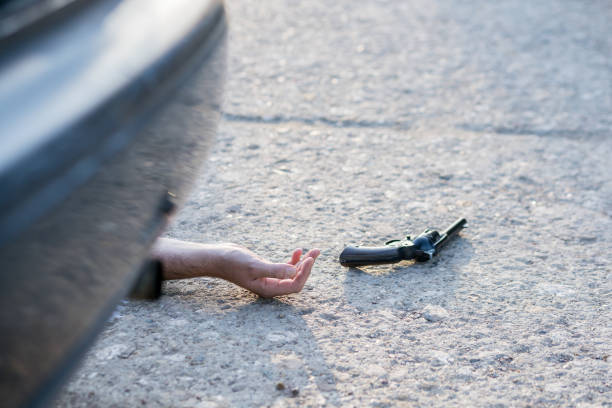 istock hand and gun at murder scene 1186570992