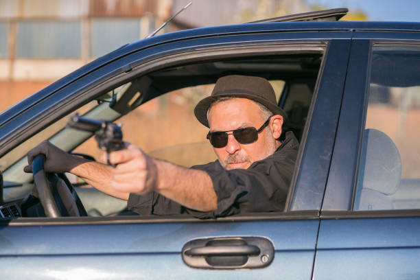 istock mobster in car perpetrating a crime 1186571015