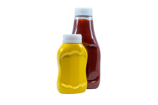 istock Yellow mustard and ketchup bottles against white. 1186571737