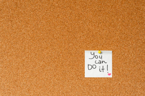 istock Believe yourself. Handwritten inspirational supportive lettering on a sticker on a cork board. Background and texture. 1186574028