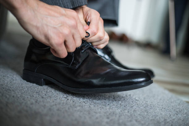istock Man puts on his shoes 1186575726