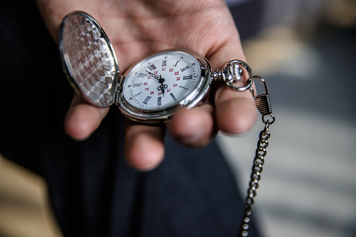 Man holding stylish pocket watch in his hand