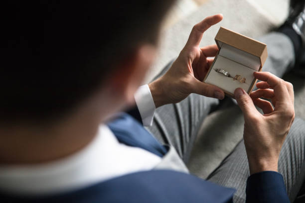 Groom holding wedding rings Man looking at wedding rings in a jewelry box in his hand jewelry box photos stock pictures, royalty-free photos & images