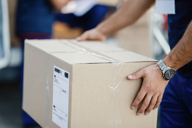 istock Close-up of courier holding a delivery box. 1186577383
