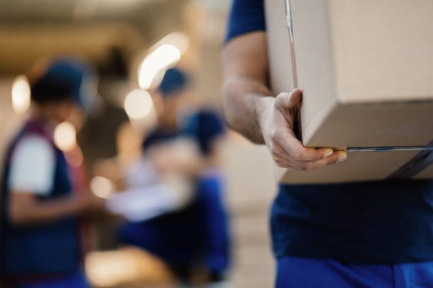 primer plano de repartidor irreconocible con caja de cartón. - package fotografías e imágenes de stock