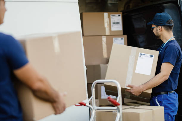 istock Manual worker preparing packages for shipment and loading them in delivery van. 1186578899