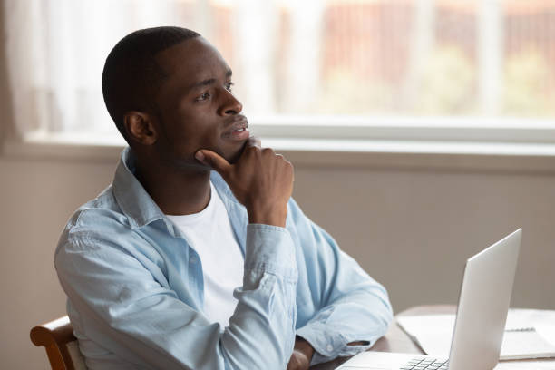 istock Pensive biracial man distracted from laptop work thinking 1186579686