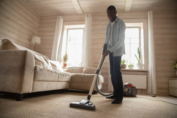 istock African American man use vacuum cleaner hovering house 1186579730