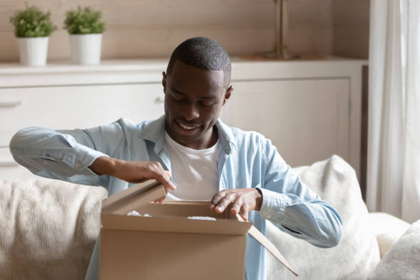 istock Happy biracial male client unpacking delivery box 1186579758