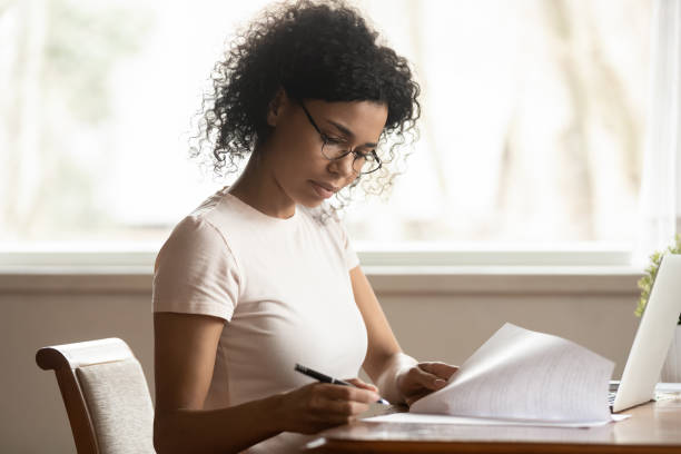 istock Focused biracial woman in glasses study correct paperwork 1186579775