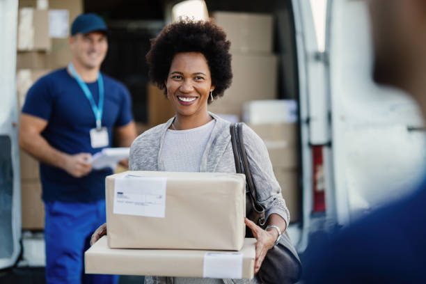 istock Happy black woman feeling satisfied while receiving package delivery. 1186580283