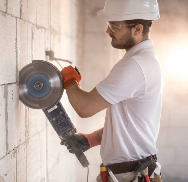 istock The industrial Builder works with a professional angle grinder to cut bricks and build interior walls. Electrician. 1186581561