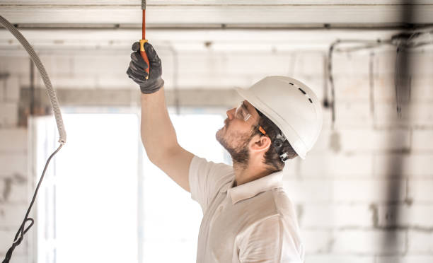 istock Electrician installer with a tool in his hands, working with cable on the construction site. 1186581571