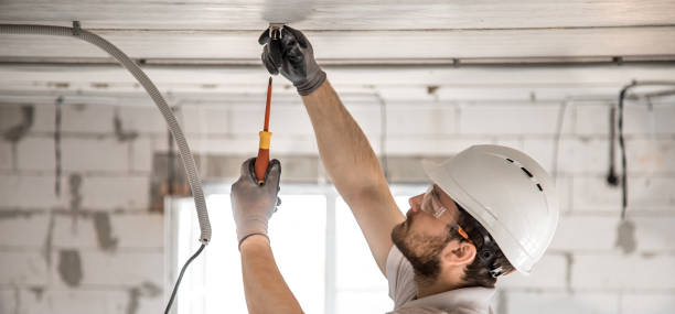 istock Electrician installer with a tool in his hands, working with cable on the construction site. 1186581574