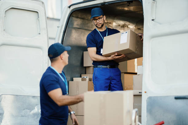 doręczyciela rozmawia ze współpracownikiem podczas załadunku pudełek w furgonetce. - delivery van delivery person messenger men zdjęcia i obrazy z banku zdjęć