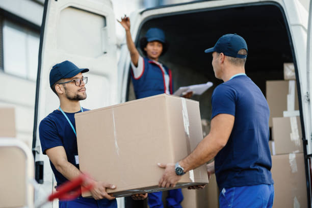 istock Male workers carrying cardboard boxes in a delivery van. 1186582376