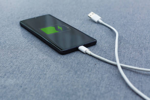 istock Mobile smart phones charging on gray background 1186590579