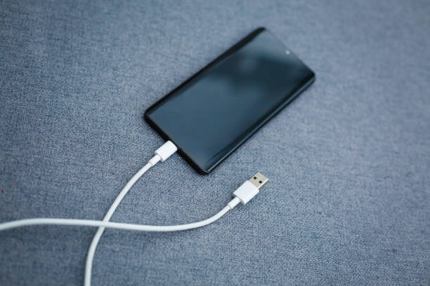 istock Mobile smart phones charging on gray background 1186590667