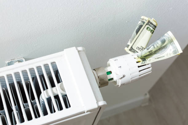 istock heating thermostat with money, dollar, expensive heating costs concept 1186590758
