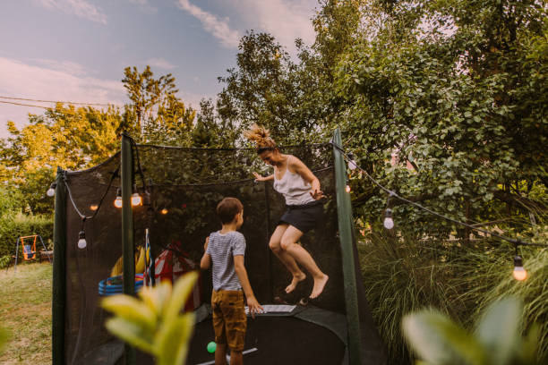 Mommy and son jumping together on a trampoline Photo of mother and son jumping together on a trampoline trampoline stock pictures, royalty-free photos & images